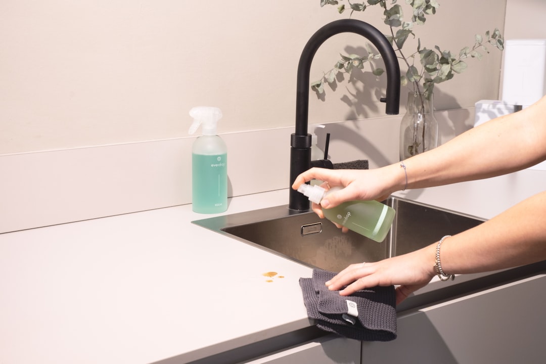 hero-img-02 a-woman-is-cleaning-a-kitchen-sink-with-a-rag-sqomdoqb3ws